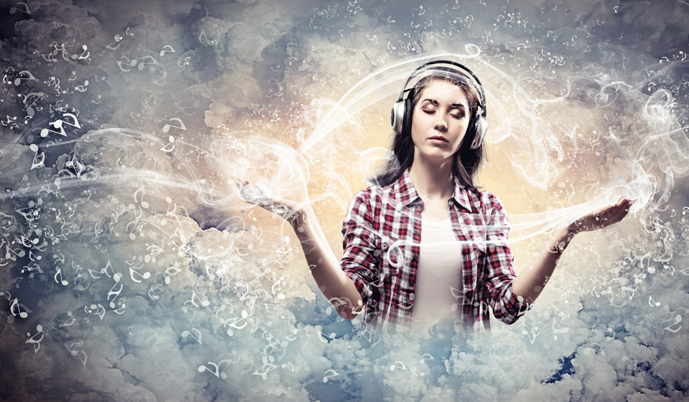 Image of young pretty woman with headphones meditating